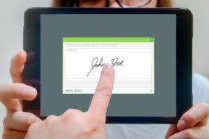 Client is signing on a tablet computer to authorize the payment. The app on screen is a self-created non-existing rendering.